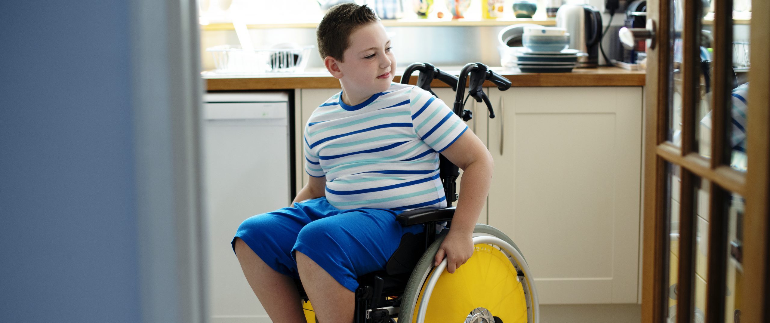 Boy using a wheelchair in a kitchen