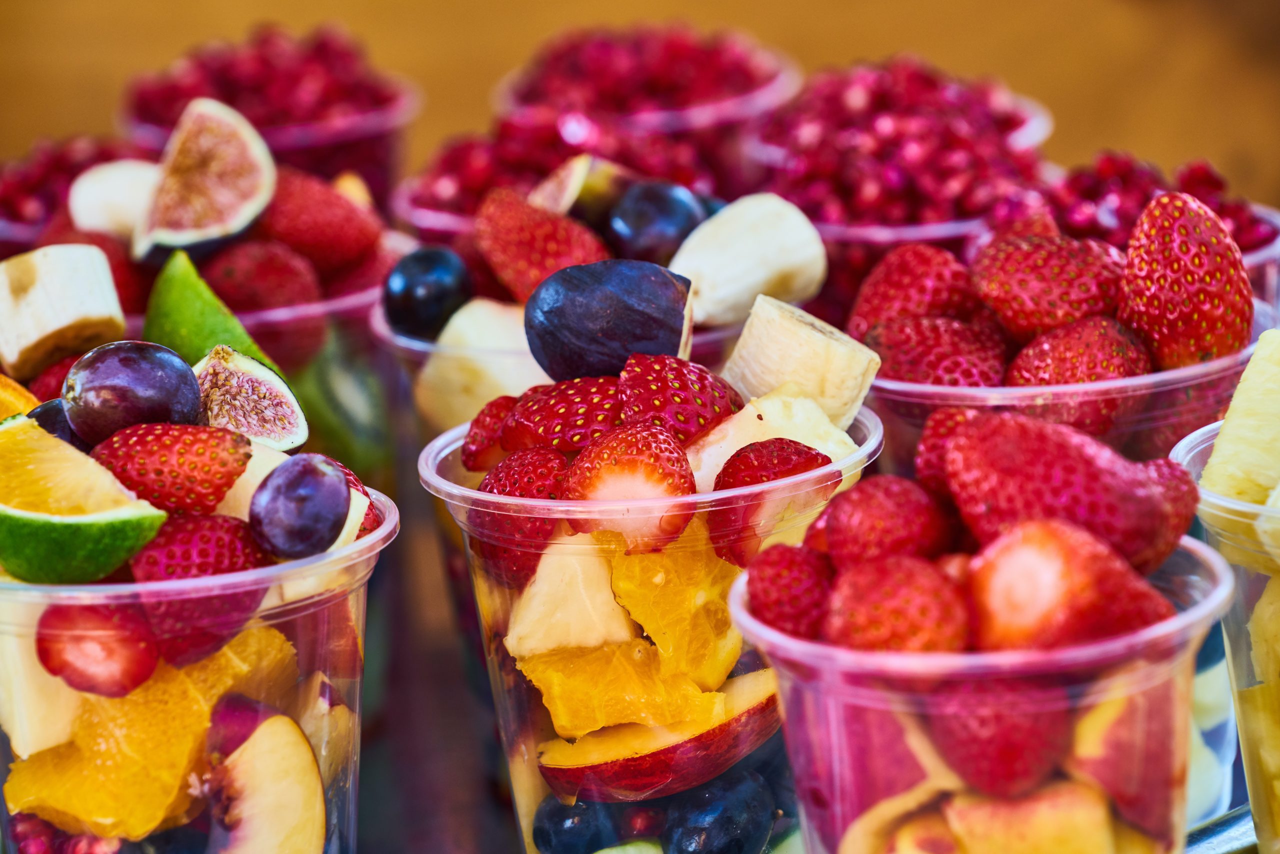 photo of colorful fruit salad in plastic cups